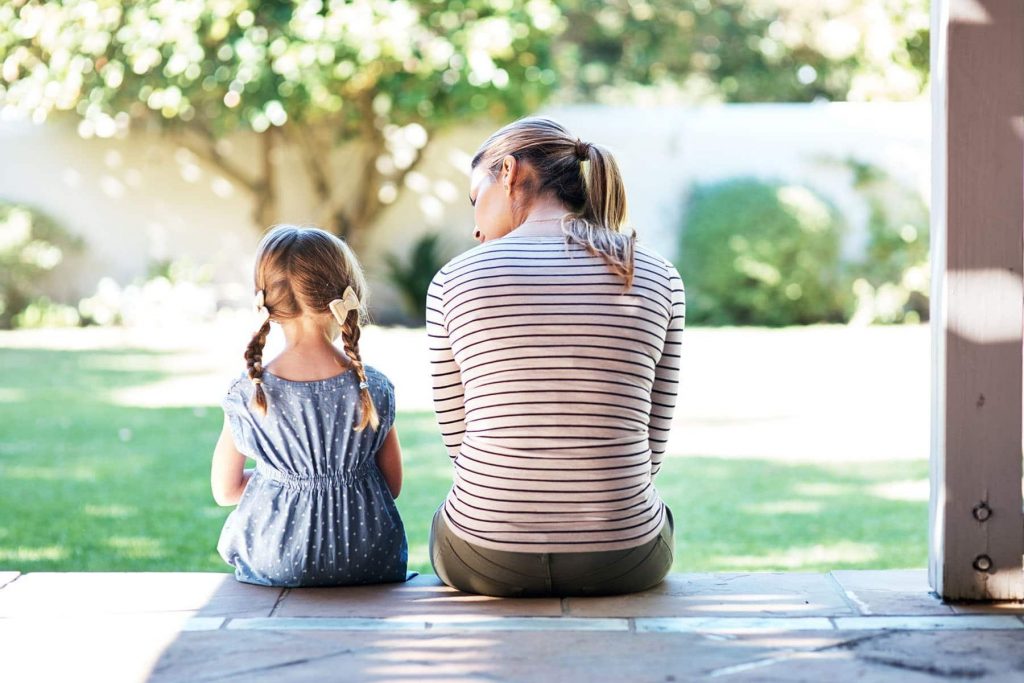 Mother helping her daughter about grief and loss while sitting outside