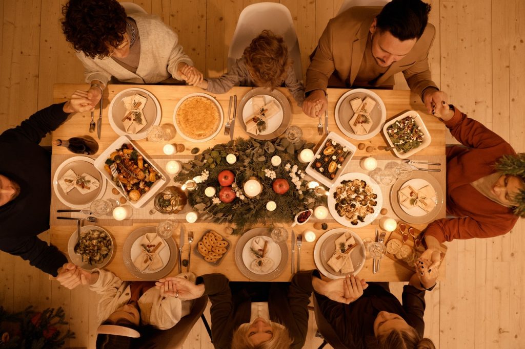 family holding hands over a dining table during christmas